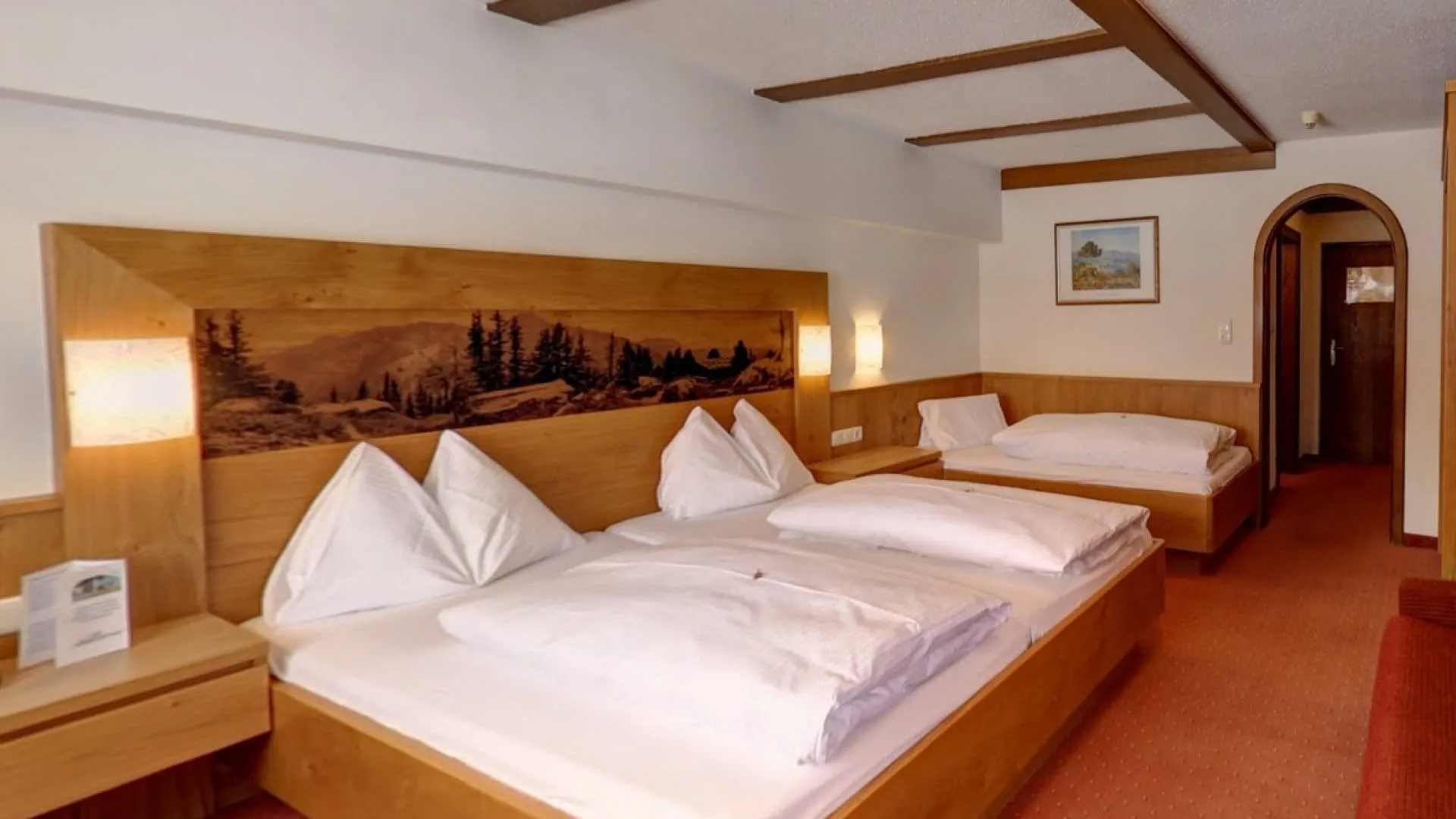 Helles Zimmer mit zwei Betten und Holzdetails, gemütlich eingerichtet.